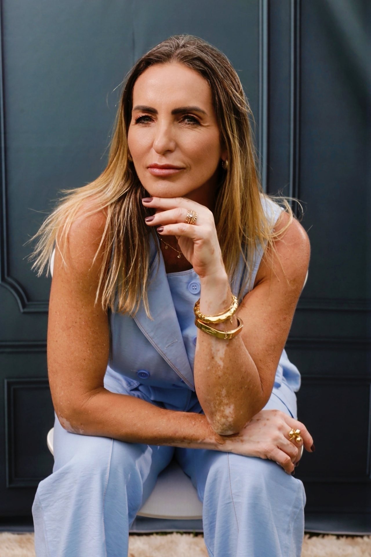 Beth Filippelle, mentora cristã e autora do Mente Renovada, sentada com a mão no queixo